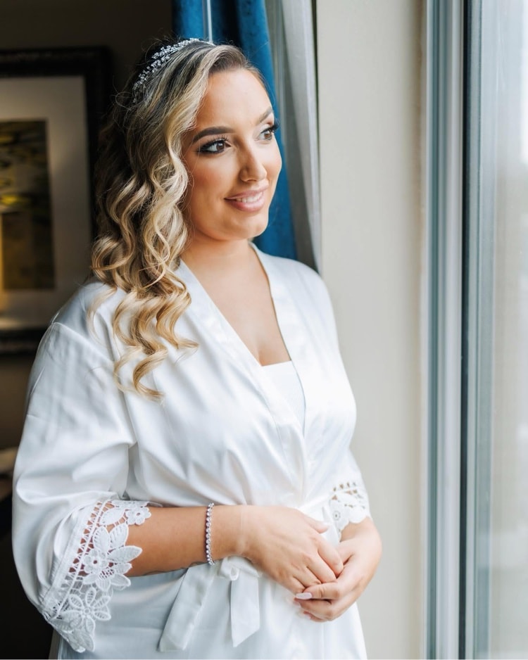 Bride in robe getting ready on her wedding day