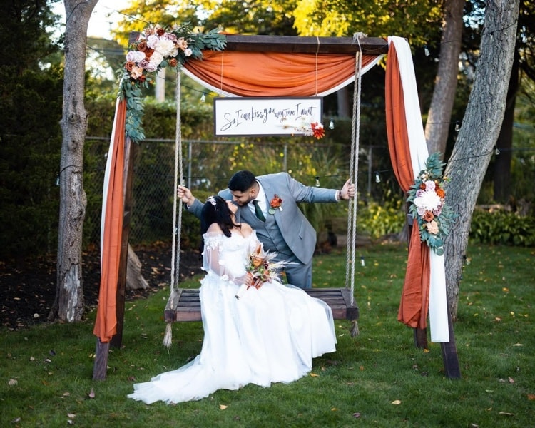 Couple sharing a kiss on a decorated swing