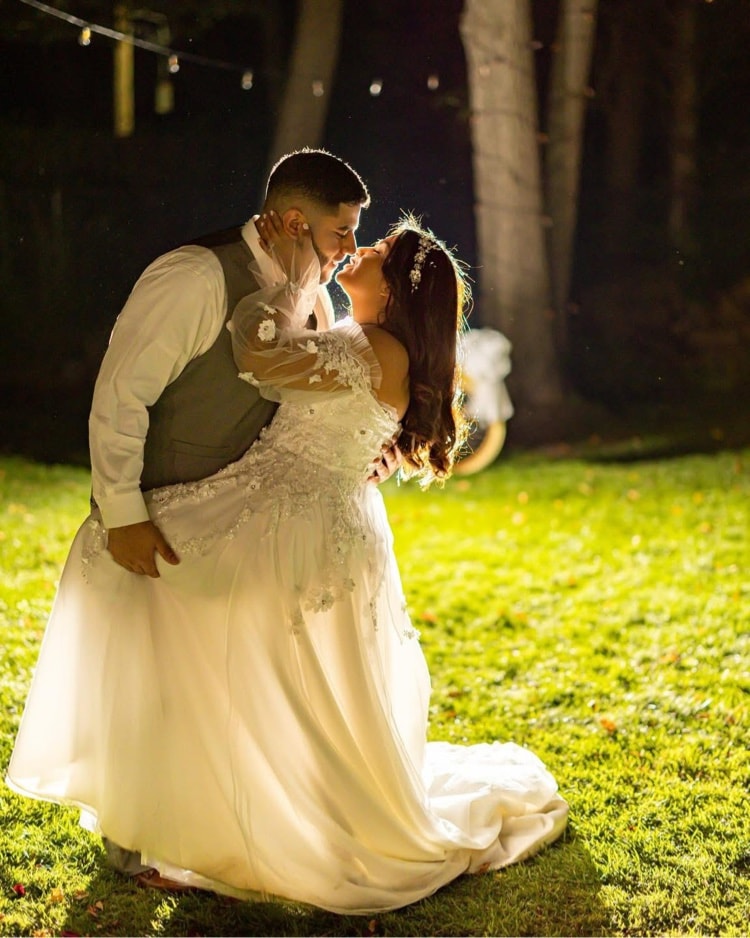 Backlit romantic couple kiss at night
