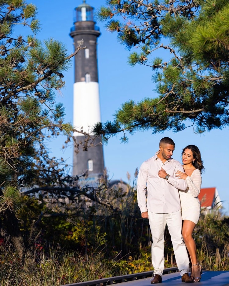 Engagement session — couple embracing in front of lighthouse