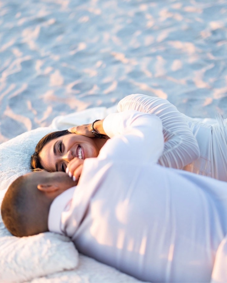 Engagement session — couple laughing together on the beach